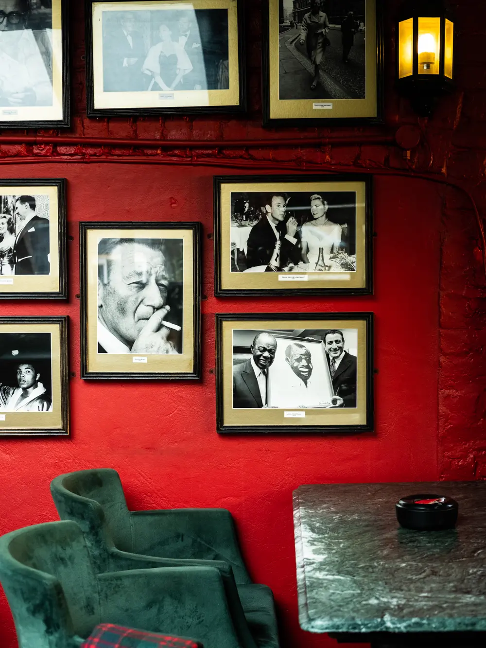 The interior of Boisale with green chairs and black and white photographs on the wall